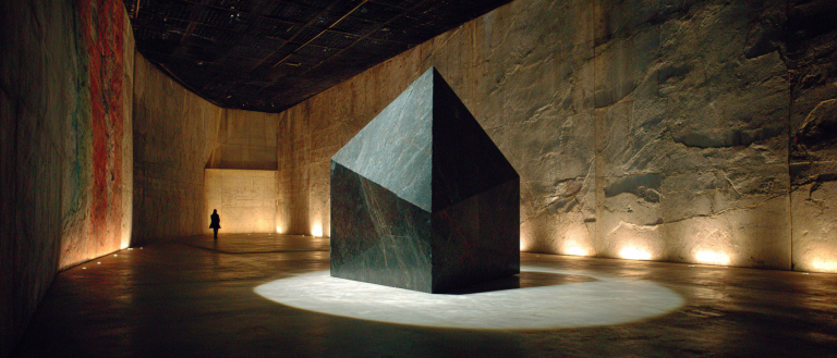 Vast near-black void, a single faceted obsidian prism suspended at right-centre