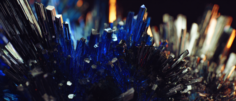 A sharp-edged crystalline form mid-dissolution in near-black void — its geometric faces intact on the right, its left boundary blurring into luminous cobalt-blue particle streams — a single volumetric raking beam from upper-right catching the solid face in warm ivory