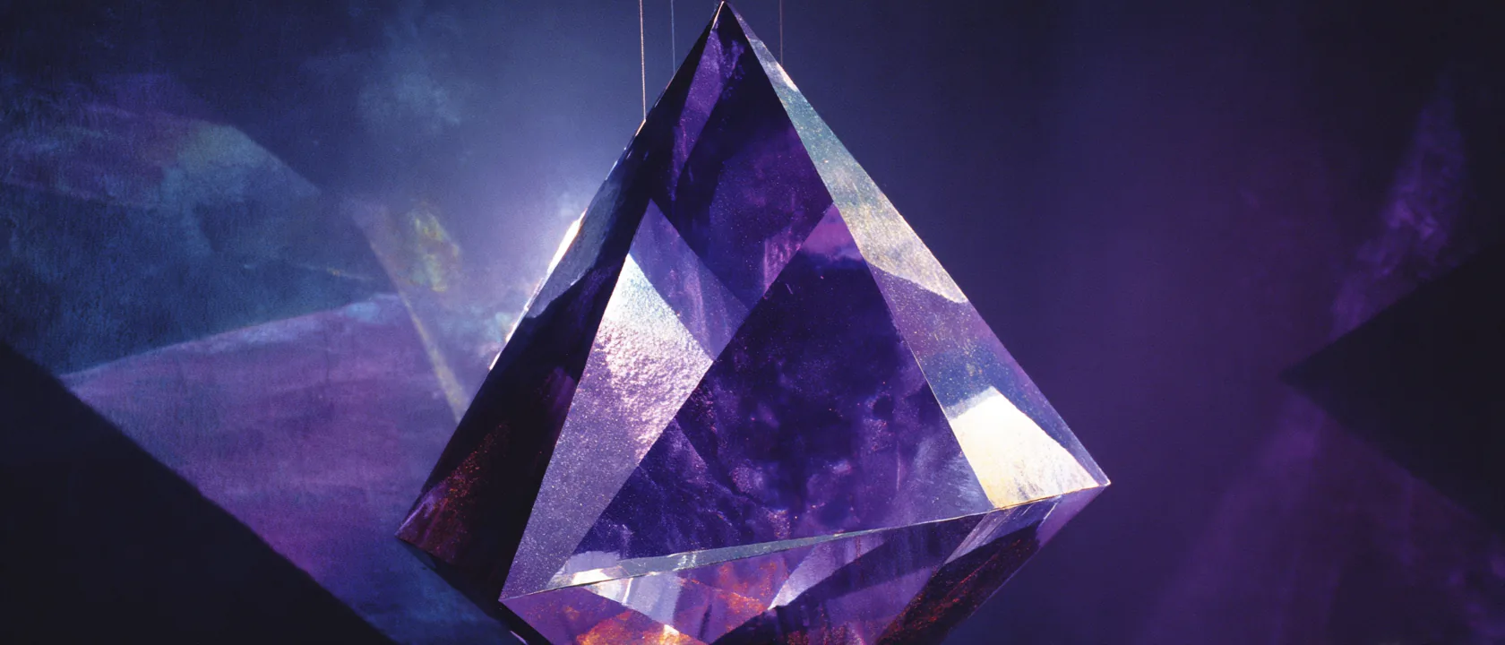 Fractured optical glass prism suspended in near-black navy void, left third pure darkness